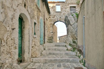 Fototapeta na wymiar A narrow street between the old stone houses of Bagnoli del Trigno, a medieval village in the Molise region of Italy.