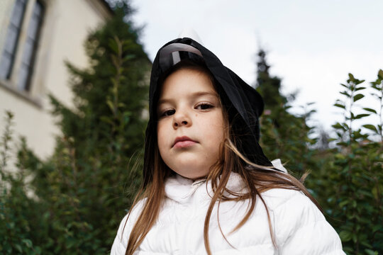 Girl with ghost mask staring in park