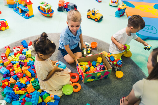 toddlers enjoying building blocks, cars, ships and other plastic toys in kindergarten. High quality photo