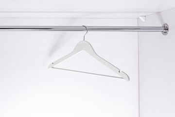 wooden light hanger for clothes hangs in wardrobe on metal rod. Accessories made of environmental...