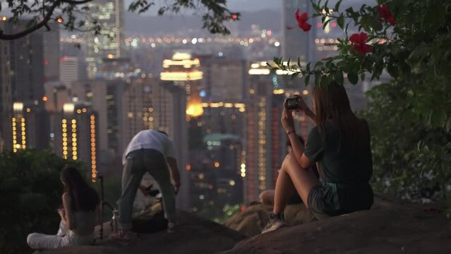 Beautiful autumn night of young lady taking photo with cityscape