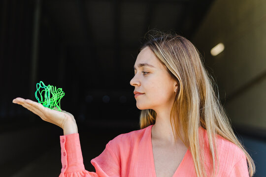 Woman looking at green metal coil toy