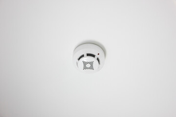 Fire alarm on white ceiling. Fire smoke detector.