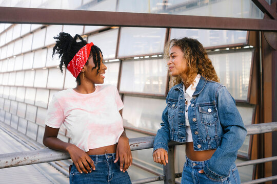 Multiracial Young Women Talking Near Railing