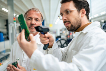 Engineer scanning circuit board with bar code scanner in industry