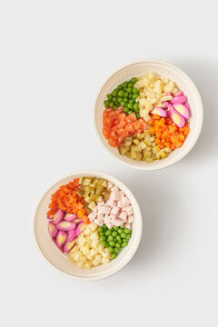 Set of bowls with fresh ingredients for Olivier salad against white background