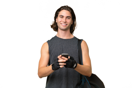 Young sport handsome man isolated on green chroma background sending a message with the mobile