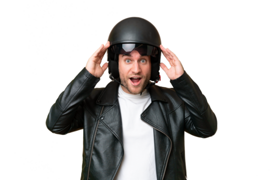 Young caucasian man with a motorcycle helmet isolated on green chroma background with surprise expression
