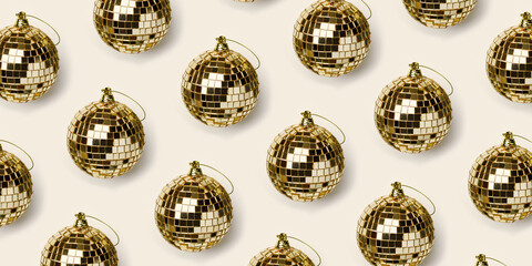 Aesthetic pattern with golden mirror balls on beige background, bright sparkling disco ball as Christmas toy, New Year, Christmas celebration, Xmas, winter holidays concept. Wide banner