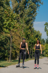 Sporty girls roller skating in park on inline skates. Female bonding.