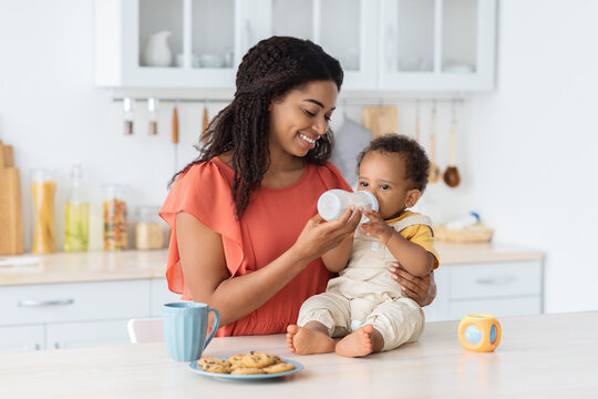 Loving Black Mom Giving Water From Baby Bottle To Her Infant Son