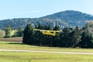 yellow Cessna airpane at take off on a sunny day