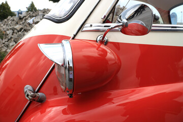 Detail eines Oldtimer Automobils mit Frontscheinwerfer und Seitenspiegel