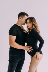Happy pregnant couple looking to the future on white background