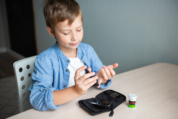Teenage boy making blood sugar test with lancing device. Medical equipment to check, control...