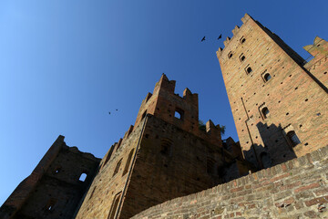 Exterior view from below of the Rocca (stronghold castle tower) of Castellâ€™Arquato, medieval village in Emilia Romagna, with blue clear sky and sunlight