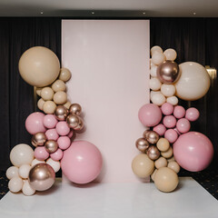 Arch with balloons, party decor. Photo-wall decoration space or place with pink, brown, and gold...