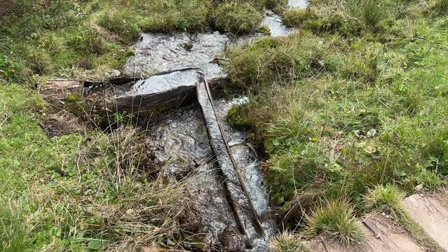 wooden standpipe on alpine hiking path