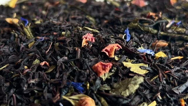 Falling dried black tea leaves. Close-up. 