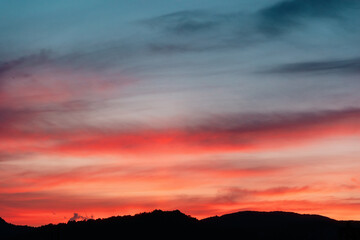 Fototapeta premium Twilight with red-blue sunset or sunrise and mountain silhouette. Sky template with copyspace. Nature background