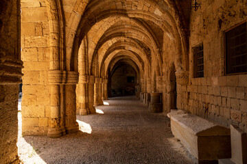 View of an ancient building through stone arches in the old town of Rhodes in Greece