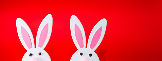 Banner,advertisement image.Two Toy Rabbit Bunnys symbol of new year 2023 on red background.Christmas or New Year concept.Copy space.