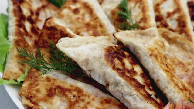 Dish with delicious fried chebureks made from dough and minced meat. Homemade fast food. Close-up