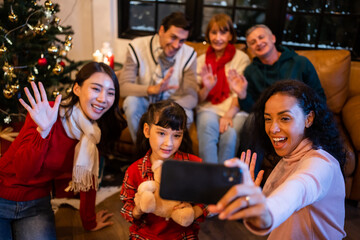 Fototapeta premium Multi-ethnic big family use mobile phone video call online to relative