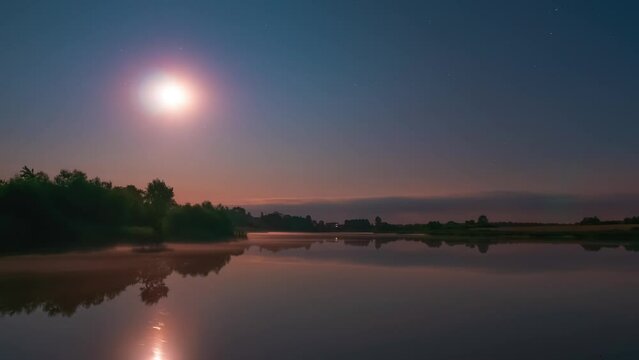 Starry night sky above a calm lake with flat water surface. Stars and moon timelapse