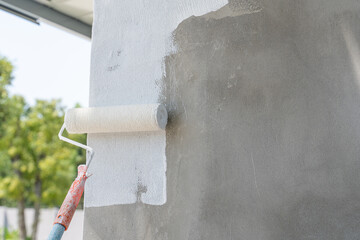 Painting of walls in a white color. Close-up house paint roller, home improvements, horizontal view...
