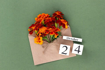 October 24. Bouquet of orange flower in craft envelope and calendar date on green background. Minimal concept Hello fall. Template for your design, greeting card