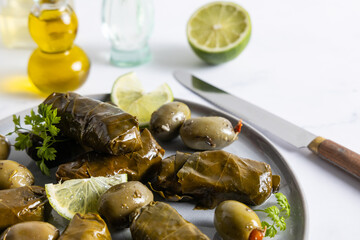 Vine leaves stuffed with rice. Organic appetizer vine leaves stuffed with rice on a plate with olives and feta cheese on the side.