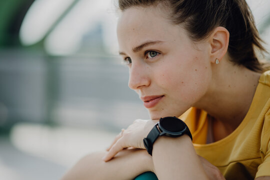Portrait of young sportive voman outdoor in city.