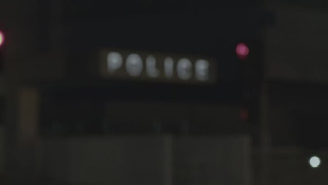 Revealing police station with focus pull rack. Cinematic shot at night