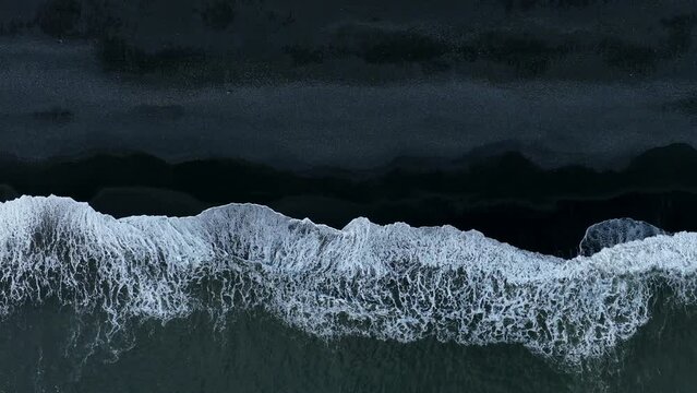 Beautiful aerial view of black beach. Sea ocean waves reaching shore.