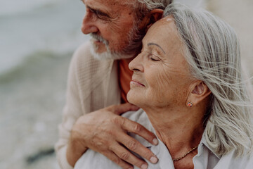 Happy senior couple relaxing and having romantic moment near the autumn sea.