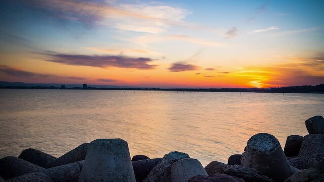 Breakwater against the background of a cloudy sky and the Black Sea with waves