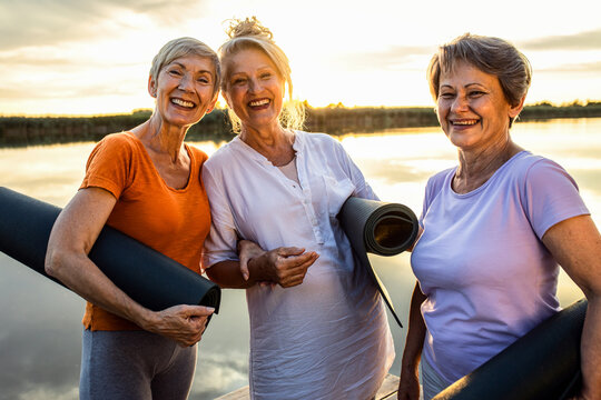 Group of senior woman with yoga mats talking after exercise.