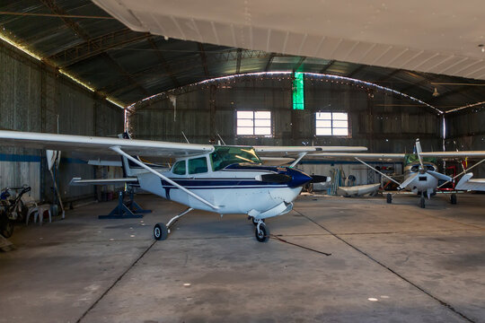 photo of old angar with several airplanes ready for flight.