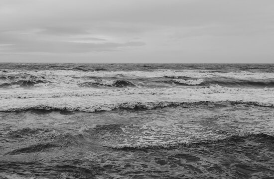 Black and white photo of the sea on a cloudy day