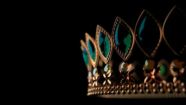 Golden crown with brilliants on black background 3D 4K looped animation with copy space. Sparkling royal corona. Close-up.