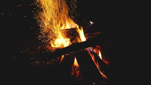 Beautiful shot of camp and fireplace fire burning in the dark at night.