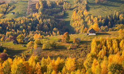 Autumn landscape in Romania. Beautiful sightseeing with the fall landscape from villages of Rucar Bran passage in Transylvania with old houses and folk scenery views. Wide angle view.
