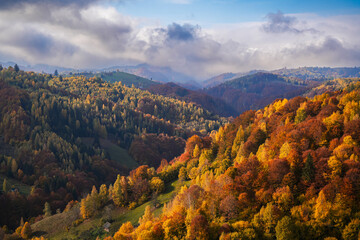 Autumn landscape in Romania. Beautiful sightseeing with the fall landscape from villages of Rucar Bran passage in Transylvania with old houses and folk scenery views. Wide angle view.
