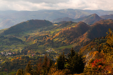 Obraz premium Autumn landscape in Romania. Beautiful sightseeing with the fall landscape from villages of Rucar Bran passage in Transylvania with old houses and folk scenery views. Wide angle view.