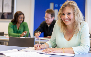 Adult Education: Happy Student. A mature student working in the classroom. From a series of related images on the subject.
