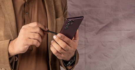 Professional holding smart phone with stylus pen on banner