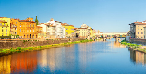 Panorama of beautiful medieval bridge Ponte Vecchio over Arno River, Florence, Italy. Architecture and landmark of Florence. Travel concept background. - obrazy, fototapety, plakaty