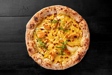 Pizza with cream cheese sauce, chicken fillet, corn, mozzarella and cheddar on black wooden surface