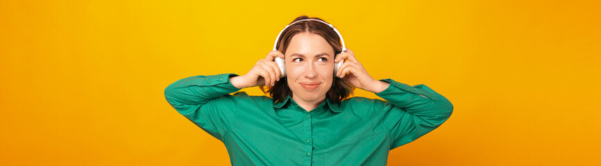 Banner shot of a cute blonde woman is wearing her headphones on the head.